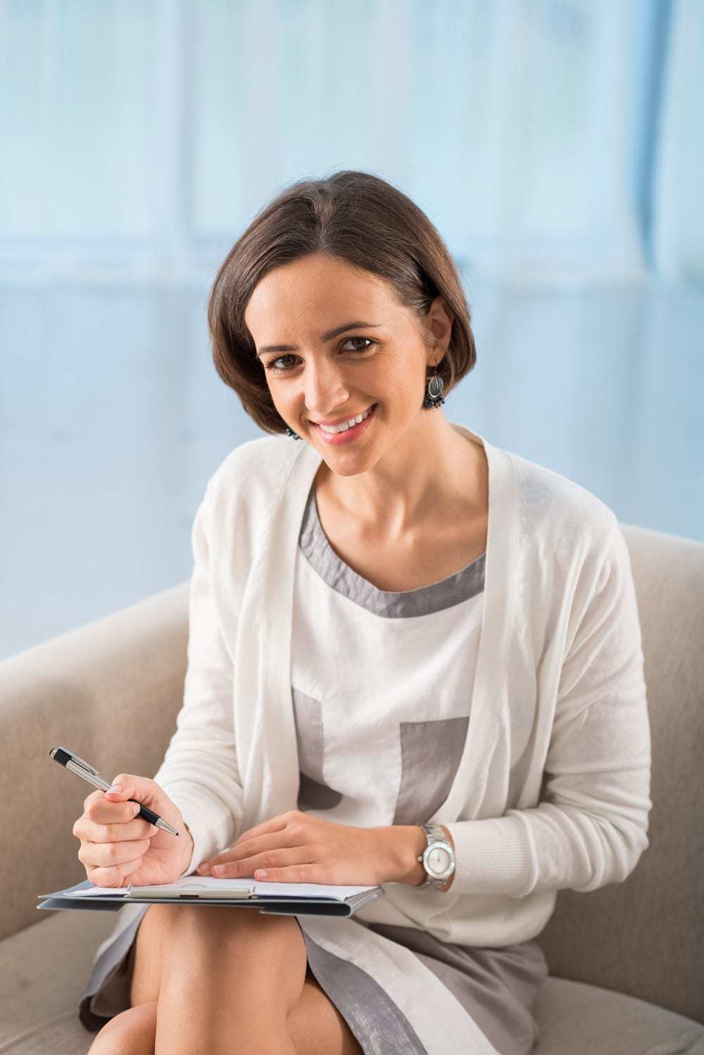 A smartly dressed Female Psychologist Smiling - the Purple House Clinic